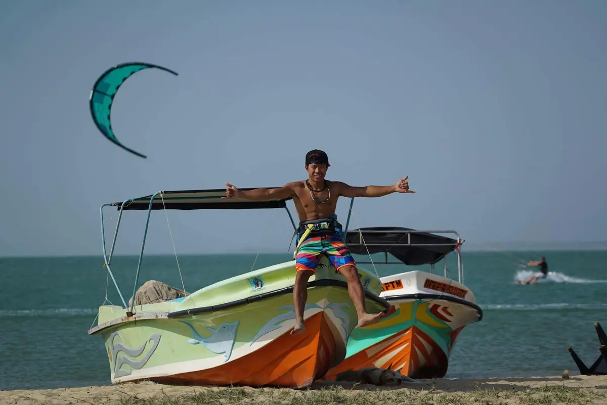 Kitesurfer beside beached boats at Dream Spot, Kalpitiya